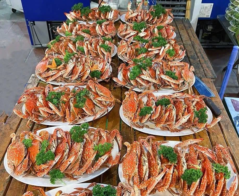 Các đĩa cua chín trang trí rau xanh trên bàn bếp