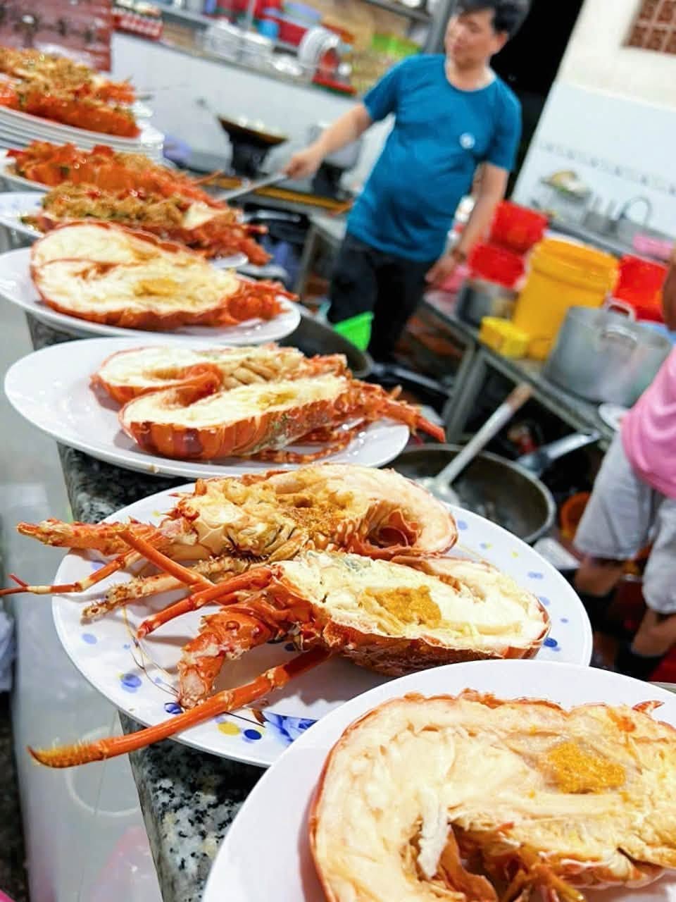 Tôm hùm nướng phô mai được bày trên đĩa tại quầy bếp