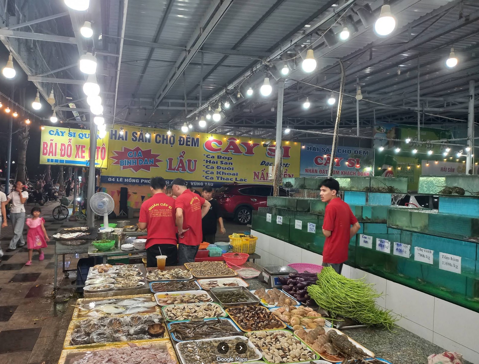 Nhân viên bên quầy trưng bày hải sản và dãy bể tại Cây Si